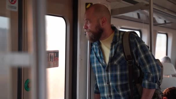 地下鉄の地下鉄または郊外の交通機関を使用してバックパックを持つ男 公共交通機関で大人の仕事をするための毎日の旅 都市生活市民が電車で地下旅客を使用して朝に働く — ストック動画