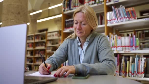 Felnőtt Főiskolai Hallgató Dolgozik Projekten Idős Laptopot Használ Egyetemi Könyvtárban — Stock videók