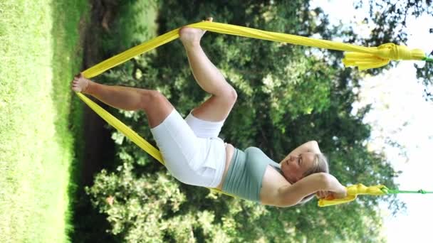 女性は公共の公園の外で一緒にトレーニングします ハンモックでヨガとストレッチ 女性の健康のためのスポーツ エクササイズはストレスを軽減し 内部の調和を維持し 垂直の幸福に貢献する — ストック動画