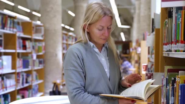 Een Vrouw Van Middelbare Leeftijd Bibliotheek Boekhandel Die Een Boek — Stockvideo