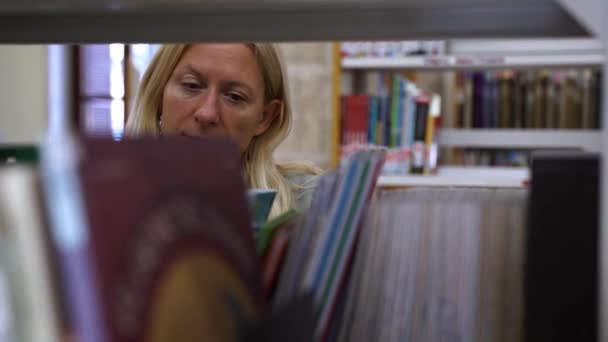 Mujer Mediana Edad Biblioteca Librería Elegir Libro Adulto Hojeando Libro — Vídeo de stock