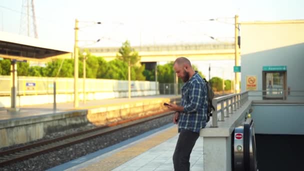 플랫폼에 지하철 기차를 기다리는 배낭과 거주자 교통에 휴대폰을 향하고 시민이 — 비디오