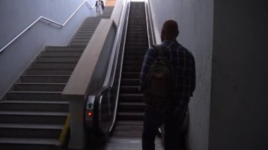 Orta yaşlı bir adam demiryolu platformunda yürüyor. Dikiz aynası. Asansör asansörünü kullanarak. Toplu taşıma yolcusu metroya biner. Banliyö sakini işe gidiyor. Sırt çantalı adam metro kullanıyor..