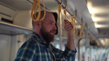 Metro vagonunu kullanan sırt çantalı bir şehir sakini. İşe giden bir yetişkin, toplu taşıma araçlarında cep telefonu kullanıyor. Sabahları şehir hayatı metroya dayanır.