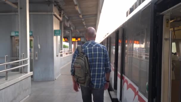 Stadsbewoner Met Een Rugzak Wandelen Langs Metro Trein Het Platform — Stockvideo
