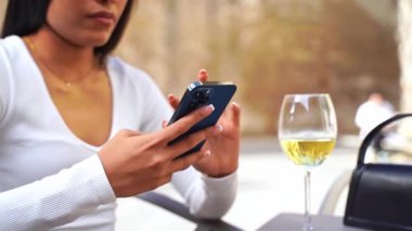 Şehir hayatı boyunca telefon kullanan güzel, genç ve güzel kadın elleri. İş kadını kafede çalışıyor. Öğrenci kontrol metni, çevrimiçi mesajlaşma, İspanyol kadın çevrimiçi alışveriş