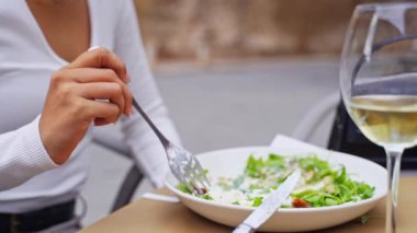 İspanyol genç kadın yemek aşığı açık hava restoranında yemeğin tadını çıkarıyor. Vejetaryen yemeği yeşil salata yer. Günlük mutlu sağlıklı alışkanlıklar. Kafeterya terasında güzel bir Latin Amerikalı kadın.