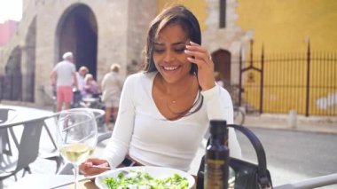 İspanyol genç kadın yemek aşığı açık hava restoranında yemeğin tadını çıkarıyor. Vejetaryen yemeği yeşil salata yer. Günlük mutlu sağlıklı alışkanlıklar. Kafeterya terasında güzel bir Latin Amerikalı kadın.