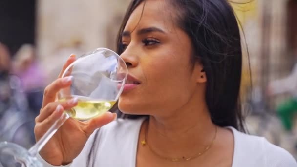 若いヒスパニック系女性は ヨーロッパ旅行中にカフェ パティオの外でワインを飲んでいる ワインの排気 レクリエーション 都市生活の休憩 リラックスした習慣 日常生活におけるアルコール テイスティングドリンク — ストック動画