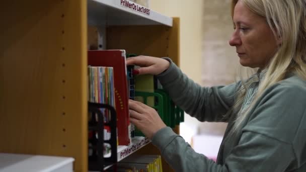 Женщина Средних Лет Библиотеке Книжном Магазине Выбирает Книгу Взрослые Перелистывают — стоковое видео