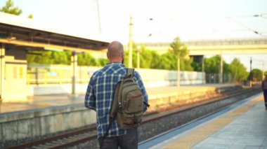 Platformda metro treni boyunca yürüyen sırt çantalı bir şehir sakini. İşe giden bir yetişkin, toplu taşıma araçlarında cep telefonu kullanıyor. Sabahları şehir hayatı metroya dayanır.