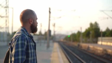 Sırt çantalı şehir sakini platformda metro trenini bekliyor. İşe giden bir yetişkin, toplu taşıma araçlarında cep telefonu kullanıyor. Sabahları şehir hayatı metroya dayanır.
