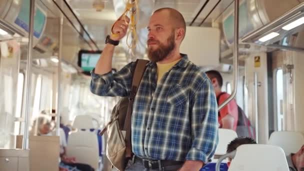 地下鉄の電車を使用したバックパック付きの都市居住者 公共交通機関で携帯電話を使用して働く大人の見出し 市民が地下鉄に依存する朝の都市生活 — ストック動画