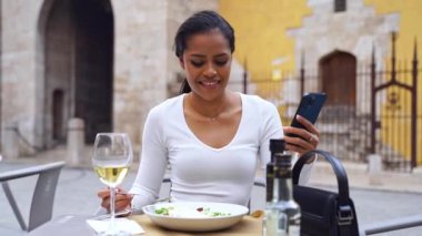 Şehir hayatı boyunca telefon kullanan güzel, genç ve güzel kadın elleri. İş kadını kafede çalışıyor. Öğrenci kontrol metni, çevrimiçi mesajlaşma, İspanyol kadın çevrimiçi alışveriş