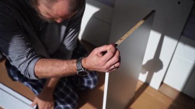 Kafkasyalı adam mobilya montajı, gardırop, çivi ve tornavida vidaları yapıyor. Yetişkin bir zanaatkar ev tamiri yapar.