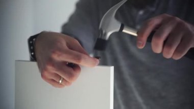 Kafkasyalı adam mobilya montajı, gardırop, çivi ve tornavida vidaları yapıyor. Yetişkin bir zanaatkar ev tamiri yapar.