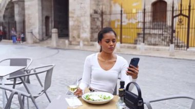 Şehir hayatı boyunca telefon kullanan güzel, genç ve güzel kadın elleri. İş kadını kafede çalışıyor. Öğrenci kontrol metni, çevrimiçi mesajlaşma, İspanyol kadın çevrimiçi alışveriş