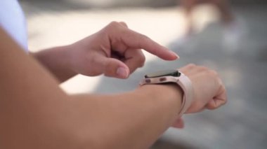 Spor etkinliği uygulaması, takip cihazı, hız, kalp atışı koşucusu uygulaması çalıştırmadan önce akıllı saat kullanarak koşan kadın ellerini kapat. Alet takip sonuçları ve spor uygulamaları kullanarak idmandan sonra koşucu yetişkin.
