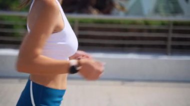 Asyalı yetişkin kadın koşucu spor kıyafetleriyle koşuyor güneşli bir sabah kentsel yüksek teknoloji şehir fütüristik geçmişi var. Koşu maratonu, dayanıklılık, kalp egzersizi sağlıklı yaşam tarzı.