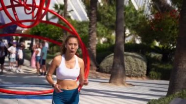 Asyalı yetişkin kadın koşucu spor kıyafetleriyle koşuyor güneşli bir sabah kentsel yüksek teknoloji şehir fütüristik geçmişi var. Koşu maratonu, dayanıklılık, kalp egzersizi sağlıklı yaşam tarzı.