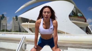 Koşu egzersizinden sonra derin nefes alan spor giysili Asyalı kadın. Amaçlara, adanmışlığa ve dayanıklılığa ulaştığım için mutluyum. Spor maratonu koşan yetişkinler dışarıda. Tatmin egzersizi.