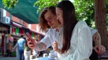 Genç turistler, antik Avrupa Türk anıtı arka planında akıllı telefondan selfie çekiyorlar. Kaşiflerin tarihi yapı kalesine turistik gezileri var. Seyahat sırasında teknoloji