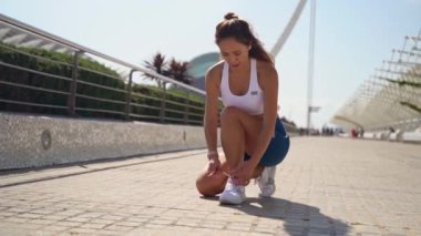 Asyalı yetişkin kadın koşucu spor giysisi ile antrenman yapmadan önce güneşli bir sabah yüksek teknoloji ürünü eşofman bağcığı hazırla. Yetişkinler için sağlıklı bir yaşam tarzı