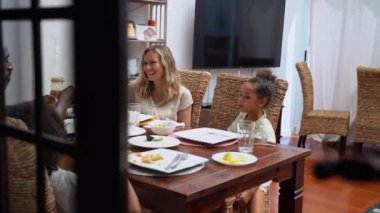 Afro-Amerikan beyaz aileler ve çocuklar hafta sonu birlikte öğle yemeği kahvaltısı yiyor. Aile geleneği, çocuklar için sağlıklı yiyecekler, boş zaman aktivitesi, bakım ve ilişkiler