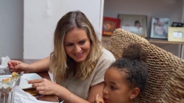 Afro-Amerikan beyaz aileler ve çocuklar hafta sonu birlikte öğle yemeği kahvaltısı yiyor. Aile geleneği, çocuklar için sağlıklı yiyecekler, boş zaman aktivitesi, bakım ve ilişkiler