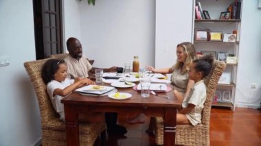 Afro-Amerikan beyaz aileler ve çocuklar hafta sonu birlikte öğle yemeği kahvaltısı yiyor. Aile geleneği, çocuklar için sağlıklı yiyecekler, boş zaman aktivitesi, bakım ve ilişkiler