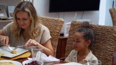 Afro-Amerikan beyaz aileler ve çocuklar hafta sonu birlikte öğle yemeği kahvaltısı yiyor. Aile geleneği, çocuklar için sağlıklı yiyecekler, boş zaman aktivitesi, bakım ve ilişkiler