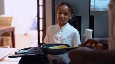 Kapatın ellerinizi, Afrikalı Amerikalı erkek şef, baba kızlarıyla birlikte evdeki rahat mutfakta krep pişiriyor. Aile geleneği hafta sonu eğlence aktivitesi