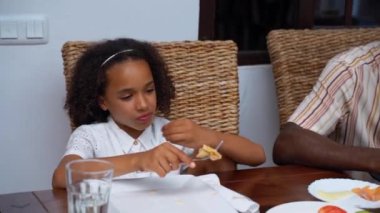 Afro-Amerikan beyaz aileler ve çocuklar hafta sonu birlikte öğle yemeği kahvaltısı yiyor. Aile geleneği, çocuklar için sağlıklı yiyecekler, boş zaman aktivitesi, bakım ve ilişkiler