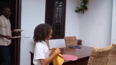 Mutlu ebeveynler ve çocuklar Afro-Amerikan Kafkas servis masasında birlikte öğle yemeği yemeden önce. Aile geleneği, çocuklar için sağlıklı yiyecekler, boş zaman aktivitesi, bakım ve ilişkiler