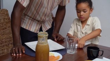 Mutlu ebeveynler ve çocuklar Afro-Amerikan Kafkas servis masasında birlikte öğle yemeği yemeden önce. Aile geleneği, çocuklar için sağlıklı yiyecekler, boş zaman aktivitesi, bakım ve ilişkiler