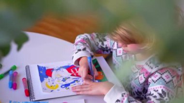 Noel Baba 'ya yeni yıl tatili için mektup yazan çocuk, rahat Noel süslemeleri ve ışıkları, renkli kalemler çizen kız, Noel Baba' ya hediyeler hazırlayan çocuk,