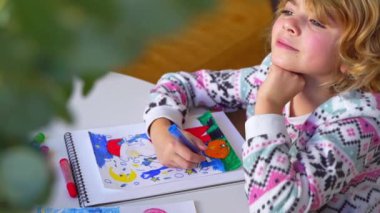 Noel Baba 'ya yeni yıl tatili için mektup yazan çocuk, rahat Noel süslemeleri ve ışıkları, renkli kalemler çizen kız, Noel Baba' ya hediyeler hazırlayan çocuk,