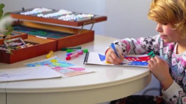 Noel Baba 'ya yeni yıl tatili için mektup yazan çocuk, rahat Noel süslemeleri ve ışıkları, renkli kalemler çizen kız, Noel Baba' ya hediyeler hazırlayan çocuk,