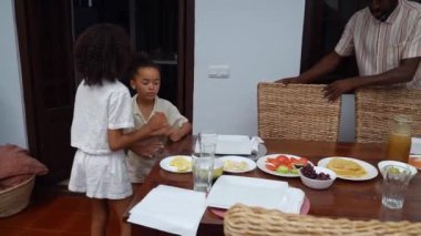 Mutlu ebeveynler ve çocuklar Afro-Amerikan Kafkas servis masasında birlikte öğle yemeği yemeden önce. Aile geleneği, çocuklar için sağlıklı yiyecekler, boş zaman aktivitesi, bakım ve ilişkiler