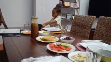 Mutlu ebeveynler ve çocuklar Afro-Amerikan Kafkas servis masasında birlikte öğle yemeği yemeden önce. Aile geleneği, çocuklar için sağlıklı yiyecekler, boş zaman aktivitesi, bakım ve ilişkiler