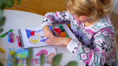 Noel Baba 'ya yeni yıl tatili için mektup yazan çocuk, rahat Noel süslemeleri ve ışıkları, renkli kalemler çizen kız, Noel Baba' ya hediyeler hazırlayan çocuk,