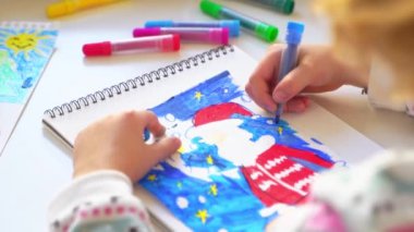 Noel Baba 'ya yeni yıl tatili için mektup yazan çocuk, rahat Noel süslemeleri ve ışıkları, renkli kalemler çizen kız, Noel Baba' ya hediyeler hazırlayan çocuk,