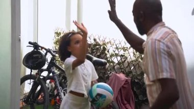 Afrikalı Amerikalı bir baba yaz zamanı kızıyla arka bahçede top oynuyor. Aile aktiviteleri, mutlu ve aktif ilişkiler yaşam tarzı. Ebeveyn ve kız çocuk hobisi