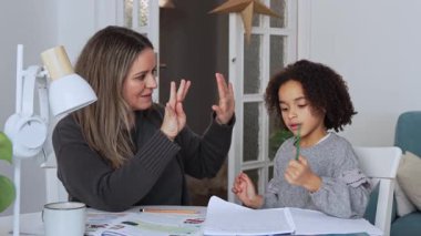 Kafkasyalı anne ve Afrikalı Amerikalı kız evde okuyor, anne evde matematik öğretiyor ev ödevlerini beyaz odada yapıyor. Ebeveyn öğretmeni, çocuk okulu kızı matematik öğrenir, egzersiz kitabı yazar.