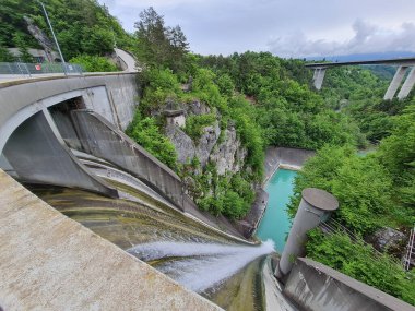 Su bir hidroelektrik barajının taşması, arka planda karayolu köprüsü