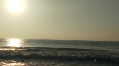Sabahın erken saatlerinde deniz kıyısında, mavi dalgalar akıyor. Renkli kış gündoğumu. Soğuk fırtınalı dalgalar ve Baltık Denizi üzerindeki bulutlar, yere vuran altın deniz dalgaları. Manzara okyanusu