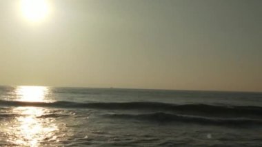 Sabahın erken saatlerinde deniz kıyısında, mavi dalgalar akıyor. Renkli kış gündoğumu. Soğuk fırtınalı dalgalar ve Baltık Denizi üzerindeki bulutlar, yere vuran altın deniz dalgaları. Manzara okyanusu