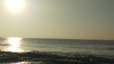 Sabahın erken saatlerinde deniz kıyısında, mavi dalgalar akıyor. Renkli kış gündoğumu. Soğuk fırtınalı dalgalar ve Baltık Denizi üzerindeki bulutlar, yere vuran altın deniz dalgaları. Manzara okyanusu