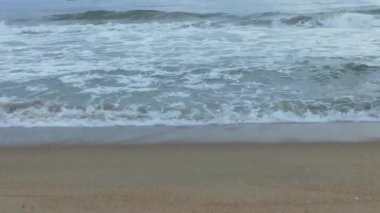 Sabahın erken saatlerinde deniz kıyısında, mavi dalgalar akıyor. Renkli kış gündoğumu. Soğuk fırtınalı dalgalar ve Baltık Denizi üzerindeki bulutlar, yere vuran altın deniz dalgaları. Manzara okyanusu