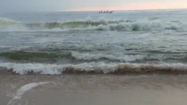 Kuzey Denizi üzerinde soğuk fırtınalı dalgalar ve bulutlar. Kuzey sahilinde kumlu bir sahilde büyük bir okyanus dalgası, beyaz kumlu tropik cennet plajı..